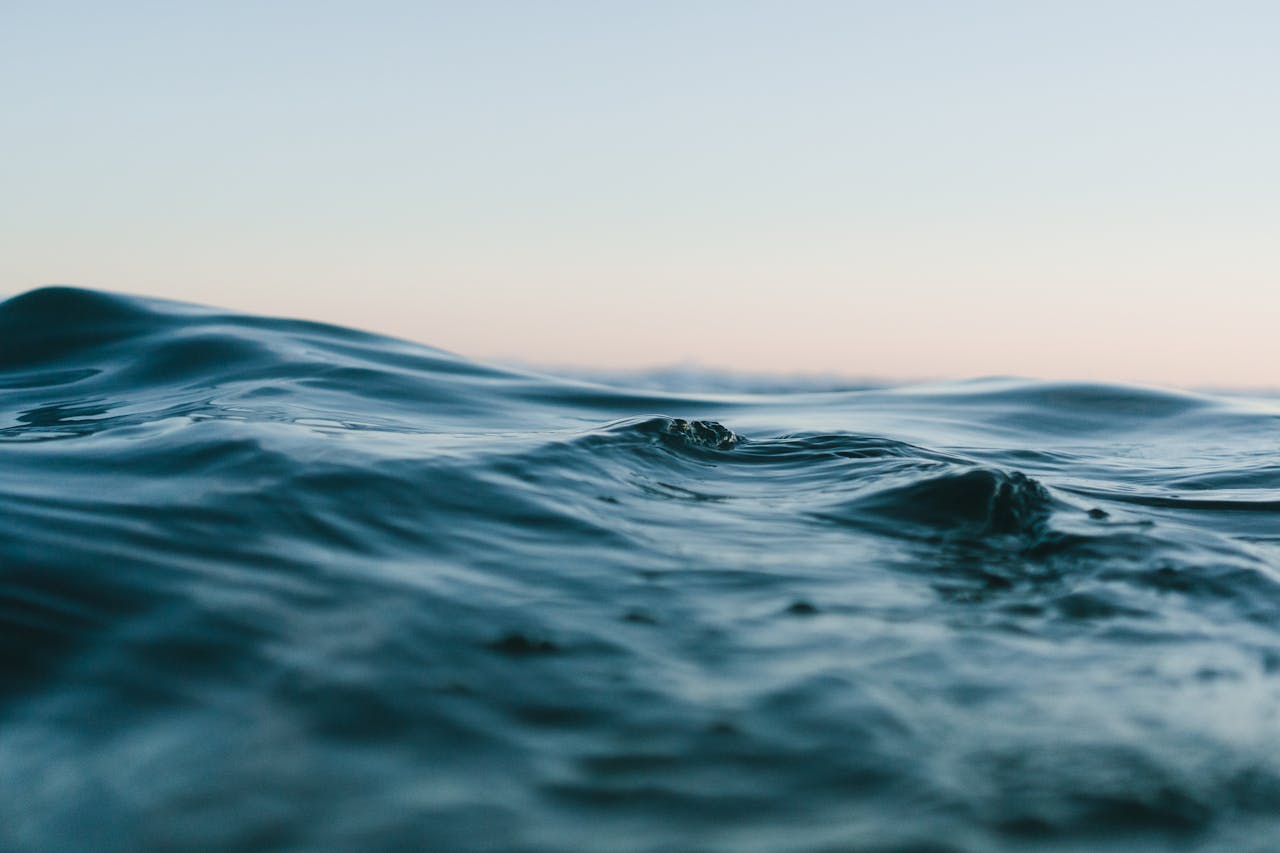 Tranquil ocean waves under a soft sunset sky, perfect for backgrounds.